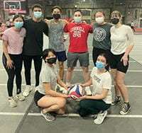 Team members posing after playing volleyball.