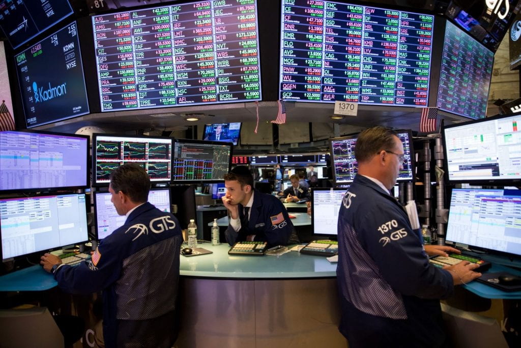 Three male stock traders at computers